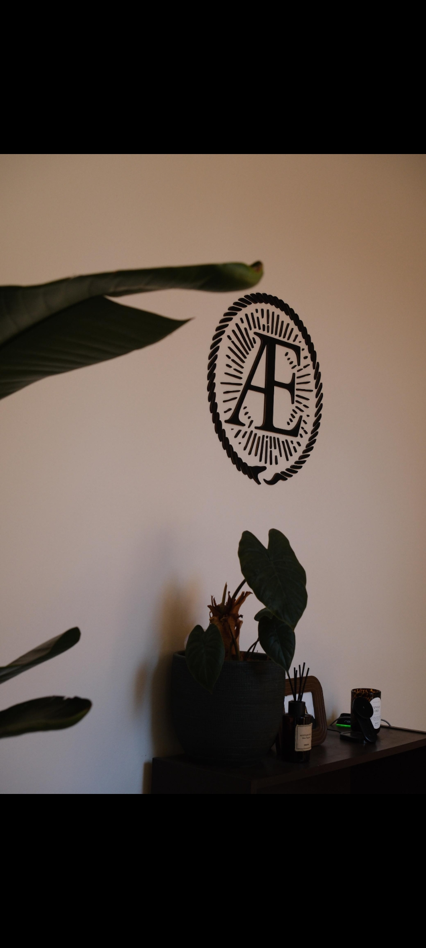 Æ Logo Wandtattoo im Studio mit Pflanzen und Kerzen